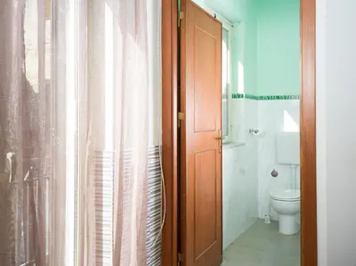 a bathroom with a toilet and a shower curtain at Isola delle Femmine - Casetta del Pescatore in Isola delle Femmine