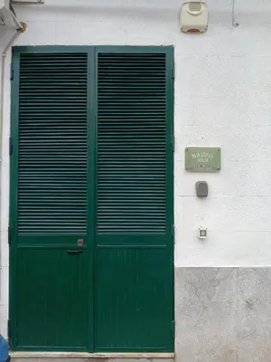 a green door on the side of a building at Maison M&M in Palermo