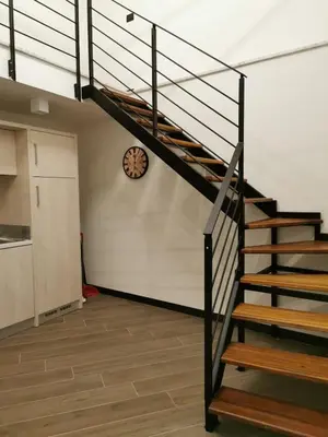 a staircase in a room with a clock on the wall at Ponticello Apartments in Palermo