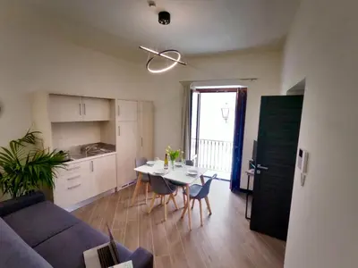 a living room with a couch and a table and chairs at Ponticello Apartments in Palermo