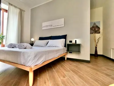 a bedroom with a large bed with a wooden floor at Ponticello Apartments in Palermo
