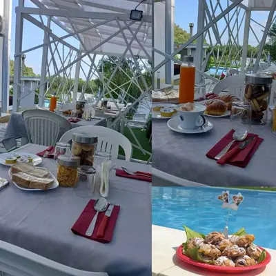 a table with food on it next to a pool at Tacco e Punta bed&breakfast in Grisi