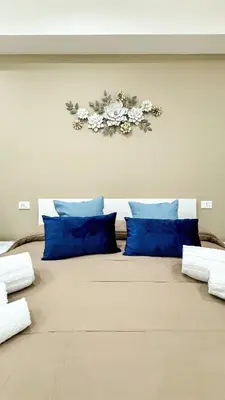 a bedroom with a large bed with blue pillows at ARIA b&b in Terrasini