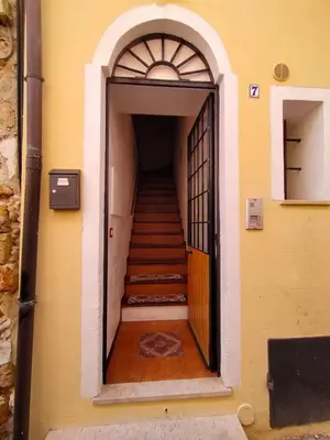 a hallway with a door and stairs in a building at A casa scalilla 2 in Palermo