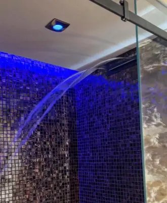 a bathroom with a shower with a blue shower at SantaTeresa19 Suite & Spa in Palermo