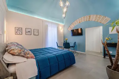 a bedroom with a blue bed in a room at Trabia25 Suite Palermo in Palermo
