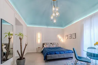 a bedroom with a bed and a table in it at Trabia25 Suite Palermo in Palermo