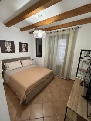 a bedroom with a bed and a chandelier at MAESTRALE CASA VACANZA in Isola delle Femmine