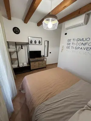 a bedroom with a bed and a tv and a mirror at MAESTRALE CASA VACANZA in Isola delle Femmine