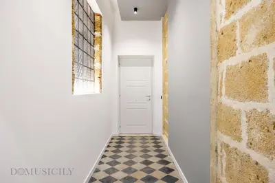 a hallway with a white door and a checkered floor at Real Tenuta Apartments By Domus Sicily in Palermo