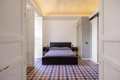 a bedroom with a bed in the middle of a room at Real Tenuta Apartments By Domus Sicily in Palermo