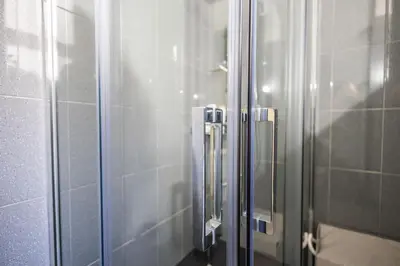 a shower with a glass door in a bathroom at Noble Suite in Palermo