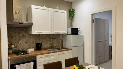 a kitchen with white cabinets and a white refrigerator at Cuba Holiday House in Palermo