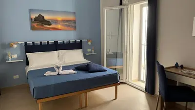 a bedroom with a bed with a pair of shoes on it at Cuba Holiday House in Palermo