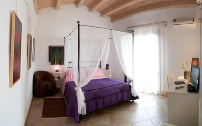 a bedroom with a bed with a canopy at Case Giannone in Santa Flavia