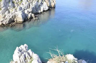 a large body of water next to some rocks at Case Giannone in Santa Flavia