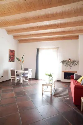 a living room with a red couch and a table at Case Giannone in Santa Flavia