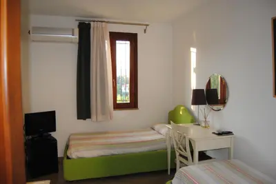 a bedroom with a bed and a desk and a window at Case Giannone in Santa Flavia