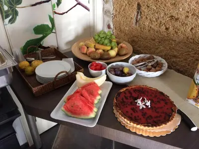 a table with a cake and fruit on it at Case Giannone in Santa Flavia