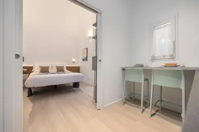 a bedroom with a bed and a table and chairs at Roccella Apartments in Palermo