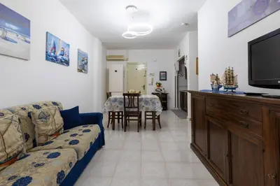 a living room with a couch and a flat screen tv at Casa Joya Apartment in Isola delle Femmine