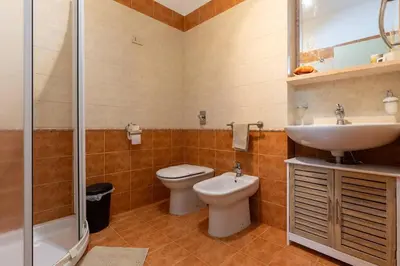 a bathroom with a toilet and a sink and a shower at Casa Joya Apartment in Isola delle Femmine