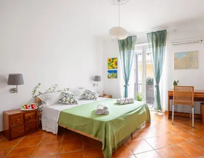 a bedroom with a bed and a table and a chair at Camera con bagno cucina e terrazza al Vicoletto al Massimo in Palermo