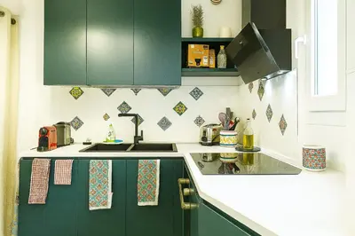 a kitchen with green cabinets and a sink at Camera con bagno cucina e terrazza al Vicoletto al Massimo in Palermo
