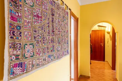 a large tapestry hanging on a wall in a hallway at Camera con bagno cucina e terrazza al Vicoletto al Massimo in Palermo