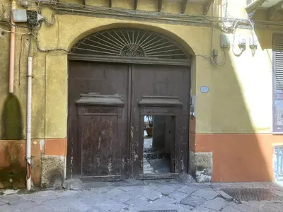 an entrance to a building with a wooden door at Camera con bagno cucina e terrazza al Vicoletto al Massimo in Palermo