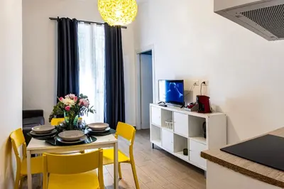 a living room with a dining room table and yellow chairs at Villafranca settantuno Apartments in Palermo