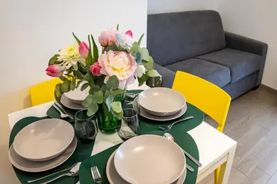 a dining room table with plates and flowers on it at Villafranca settantuno Apartments in Palermo
