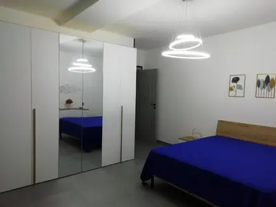 a bedroom with a blue bed and a mirror at Casa Nino' in Palermo