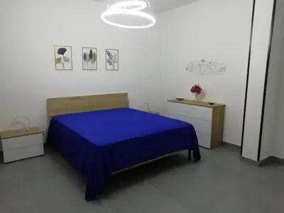 a bedroom with a bed with a blue bedspread at Casa Nino' in Palermo