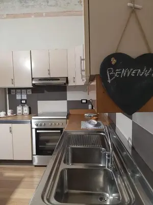 a kitchen with a sink and a heart sign on the wall at Casa Ore-Tea in Palermo