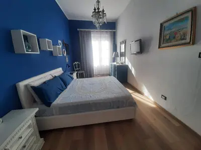 a blue bedroom with a bed and a window at Casa Ore-Tea in Palermo