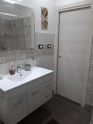 a white bathroom with a sink and a mirror at Casa Ore-Tea in Palermo