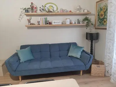 a blue couch with two pillows in a living room at Casa Ore-Tea in Palermo