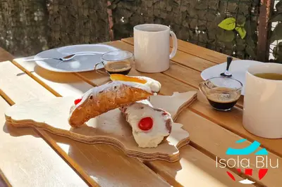 a table with two pastries and two cups of coffee at Isola Blu Casa a pochi passi dal mare in Isola delle Femmine