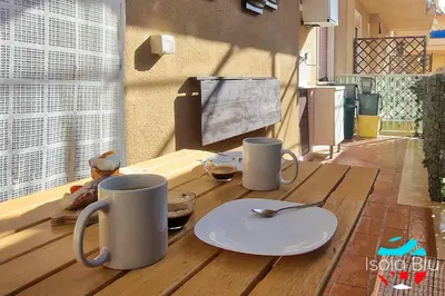 a wooden table with two mugs and a plate on it at Isola Blu Casa a pochi passi dal mare in Isola delle Femmine