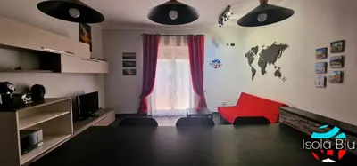 a living room with a red chair and a window at Isola Blu Casa a pochi passi dal mare in Isola delle Femmine