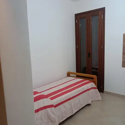 a bedroom with a bed with a striped blanket on it at Casa vacanza Acquanuova in Calatafimi