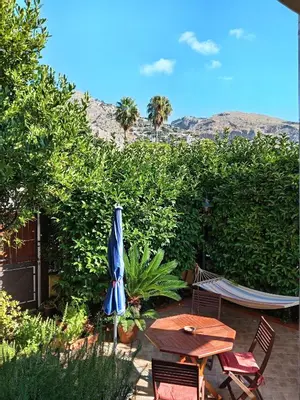 a patio with a table and a blue umbrella at alloggio in Palermo