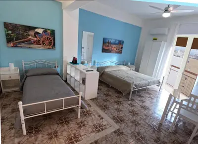 a bedroom with two beds and blue walls at Kalos in Palermo