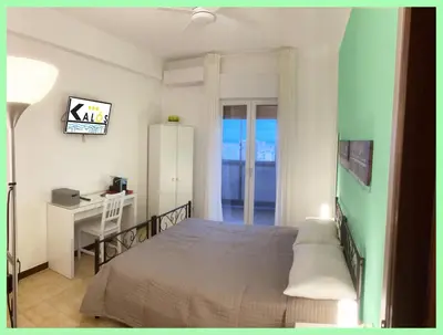 a bedroom with a bed and a desk and a desk at Kalos in Palermo