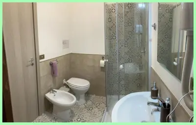 a bathroom with a toilet and a sink and a shower at Kalos in Palermo