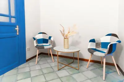 two chairs and a table in a room with a door at VICTORIO APARTMENT in Palermo