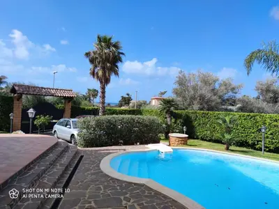 a villa with a swimming pool and a car at Casa Anna in Carini