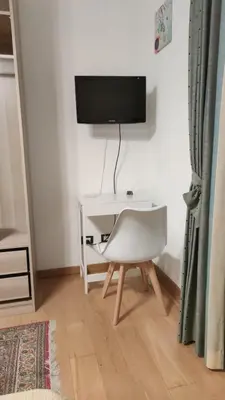 a white desk with a tv and a white chair at Casa Anna in Carini