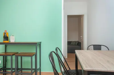 a dining room with a table and chairs and a couch at Mondello Twentytwo House in Palermo